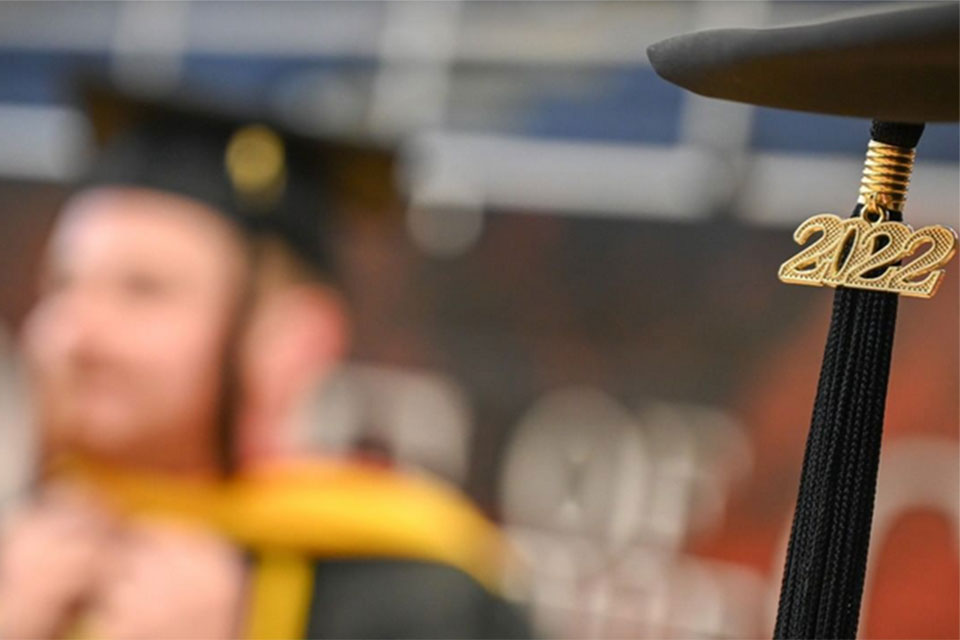 A 2022 tassle hangs from a student's graduation cap.