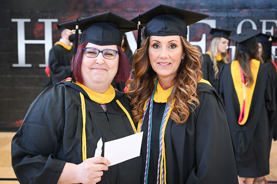 Outstanding Adult Student awardees Ashley Krul and Denise Whalley celebrate at Commencement.