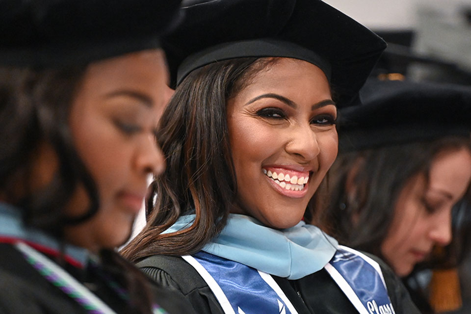 A doctoral candidate smiles during the Ralph C. Wilson, Jr. School of Education Commencement ceremony.