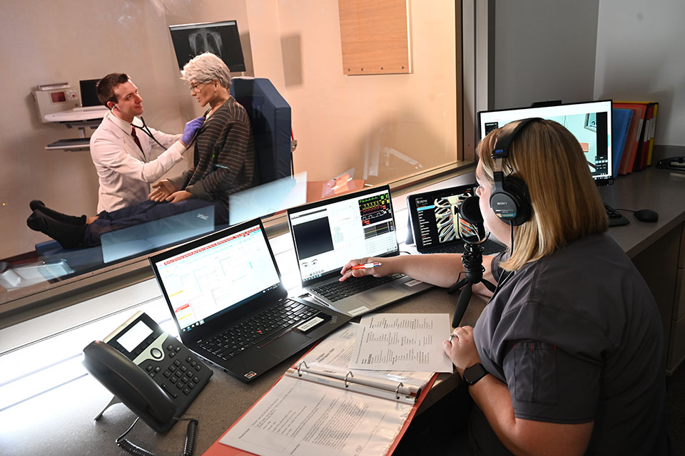 A student receives feedback from an instructor while in the IPE Sim Lab.
