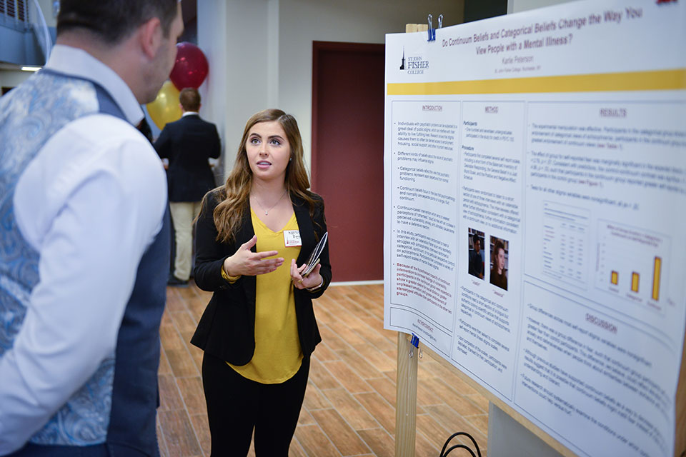 A student discusses research during the Scholarship and Creative Work Symposium.