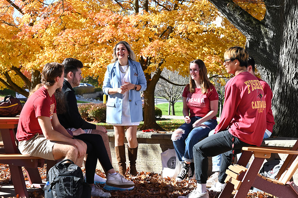 A professor talks with students.