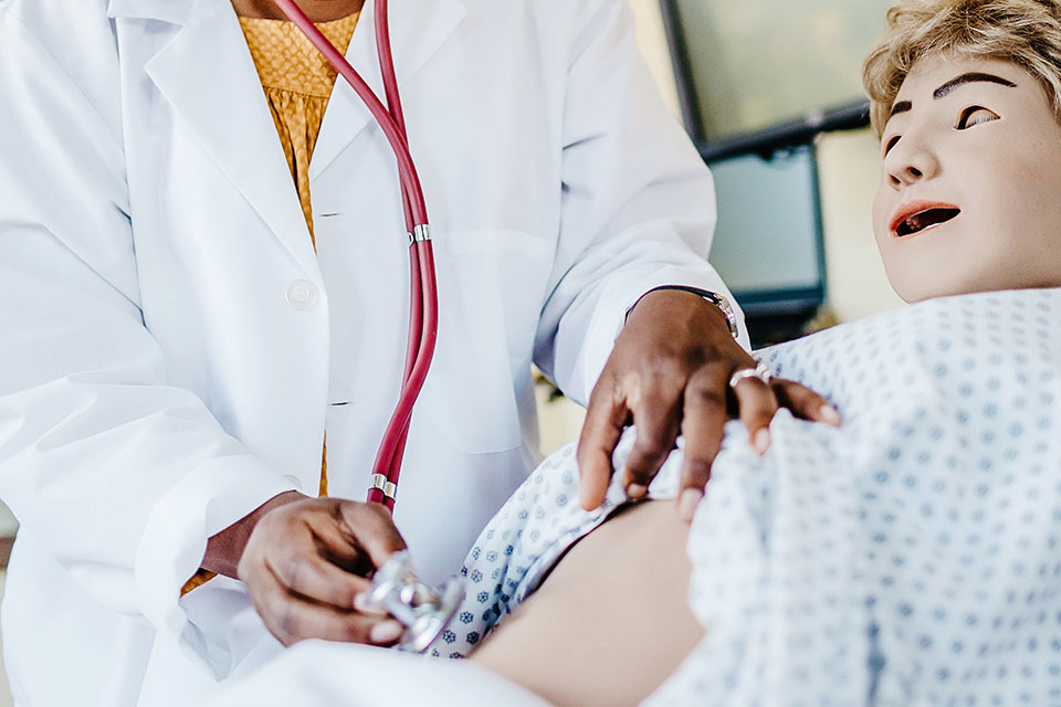 A student works on a mannequin in the nursing SIM Center.