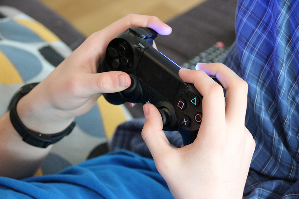 A young person holds a video game controller.
