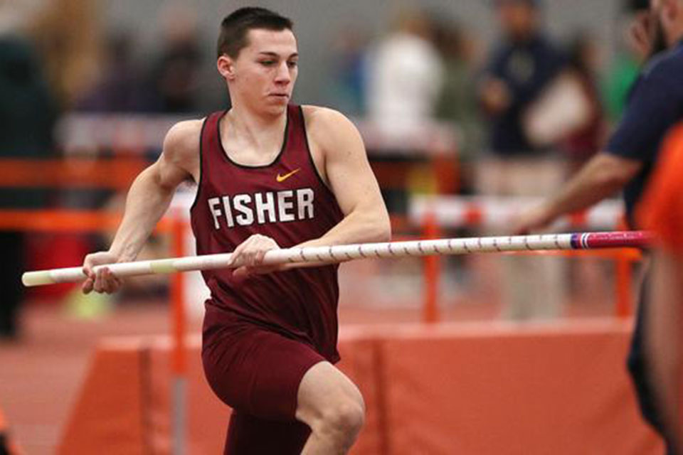 A Fisher track and field athlete attempts a pole vault.