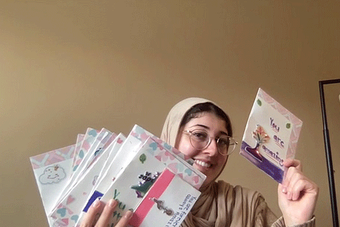 A pharmacy student holds up a selection of cards she created for Cardz for Kidz.