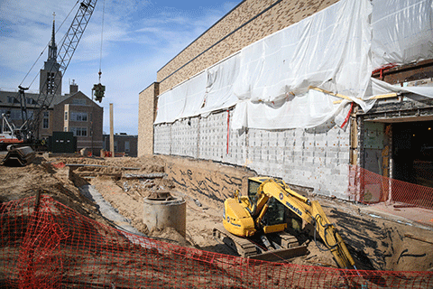 A construction vehicle moves dirt at the site of the Lavery Library renovations.