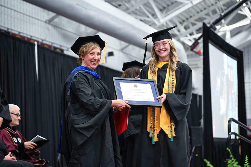 Natalie Byrd receives an award from Dean Ann Marie Fallon at Commencement.