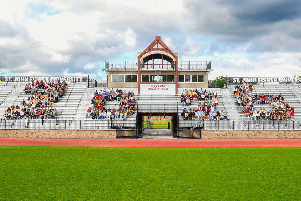 Members of the class of 2026 seated in the shape of 2026 on campus at Fisher.