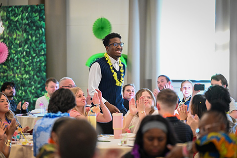 Awardee walking to receive award at the 2026 Cardinal Awards.