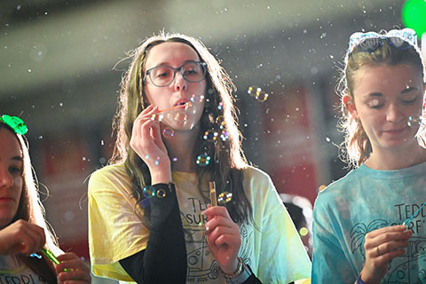 A female student at the Teddi Dance blowing bubbles