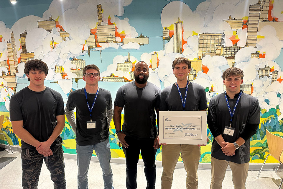 Students and faculty at the recent AI Start Up Jam, one student holding the winning check