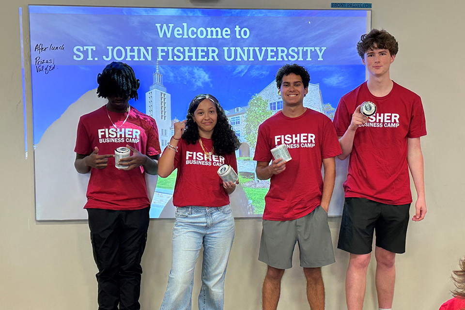 Students in Fisher Business Camp t-shirts stand together in a classroom.