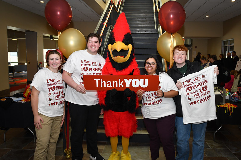 Four students stand with Beaks the mascot holding a sign that reads Thank You