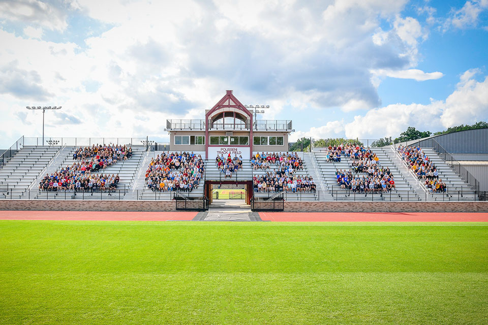 Members of the Class of 2023 spell out the numbers 2-0-2-3 on stadium bleachers.