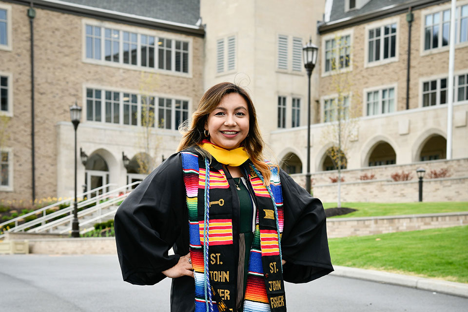 Maria Robles poses in her commencement attire in front of Kearney Hall.