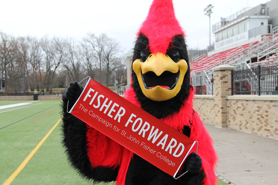 Cardinal mascot holding a sign that says Fisher Forward: The Campaign for St. John Fisher College.