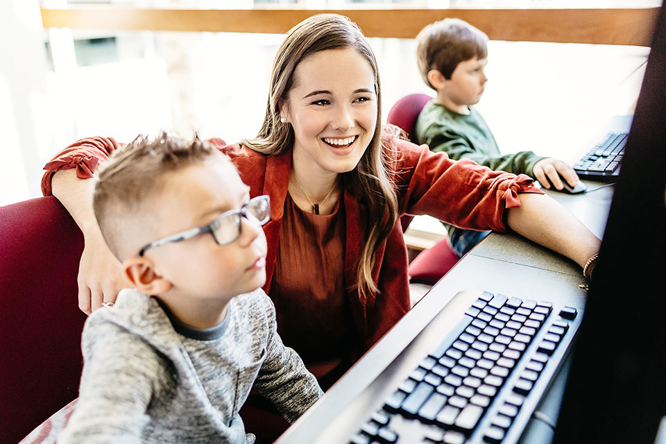 An teacher candidate works with a kindergarten student.