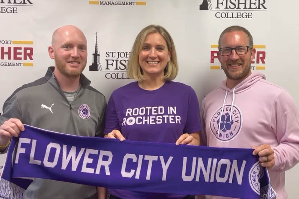 Patrick Gordon, Katie Burakowski, and Todd Harrison holding a Flower City Union banner