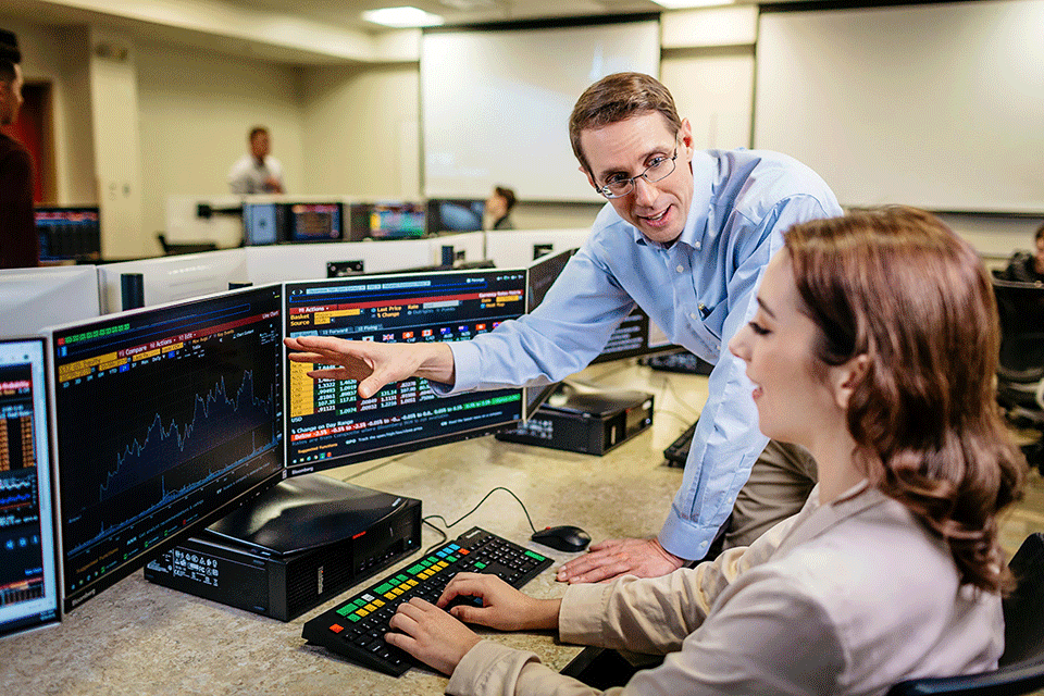A professor and student use the Bloomberg Terminals.