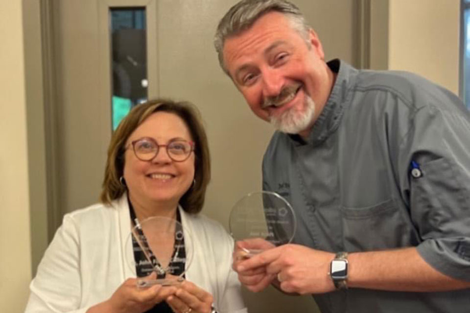 Andrea Maccarone and Chef Joel Kraft celebrate Fisher Dining Services two awards.