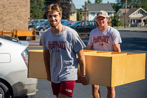 During the Cardinal Community Blitz, football players helped move furniture at St. Ambrose Aacdemy.