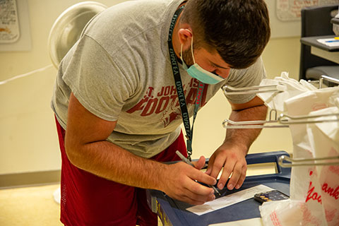 A football player volunteers at Trillium Health.