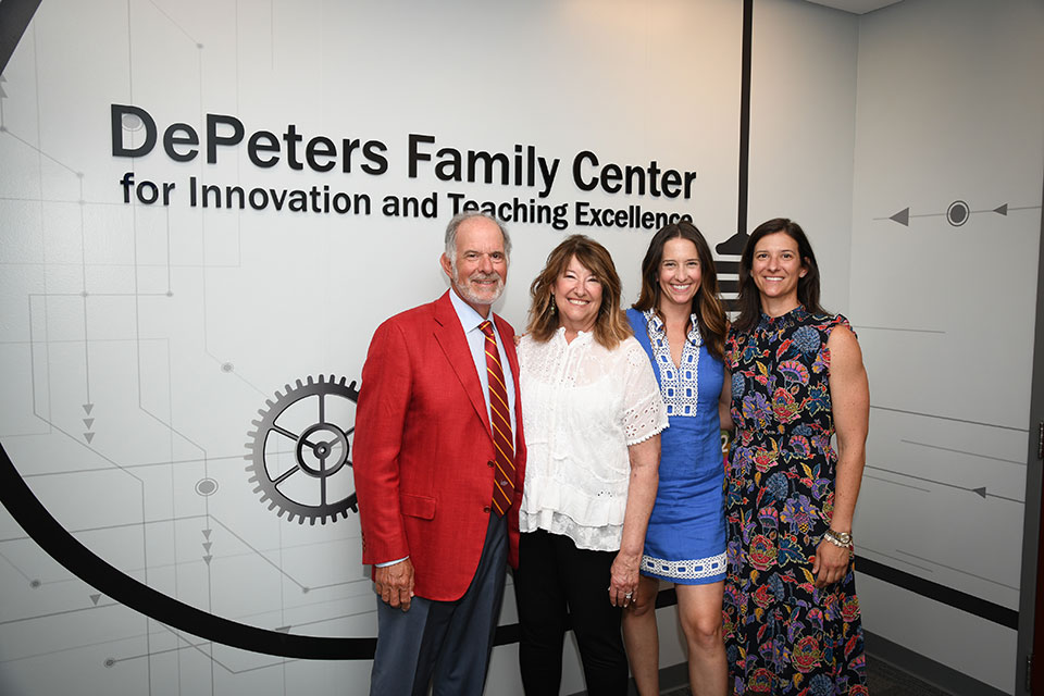 Jack and Donna DePeters pose with their daughters in front of the center that bears their names.