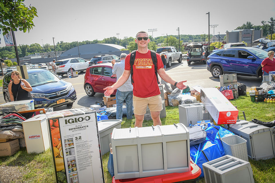 A first-year student is surrounded by boxes during Move-In Day 2022.