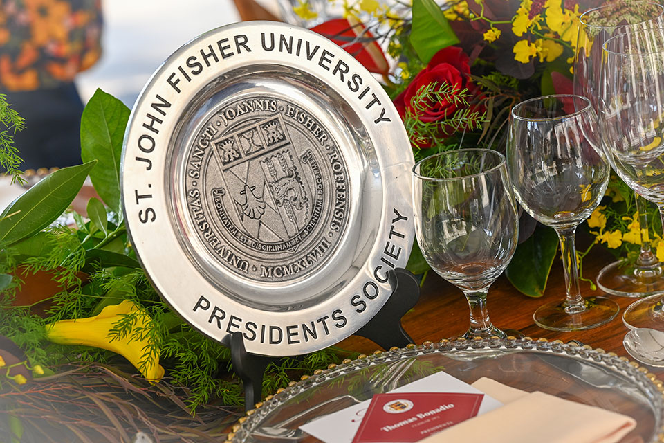 A Presidents Society commemorative plate is displayed at a place setting.
