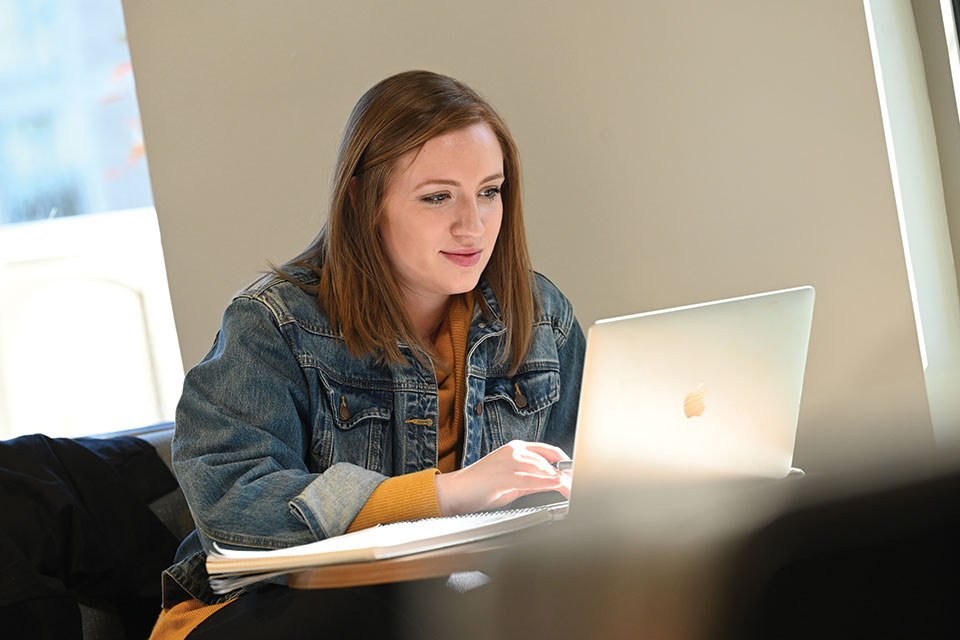 A student works on a laptop in Tepas Commons.