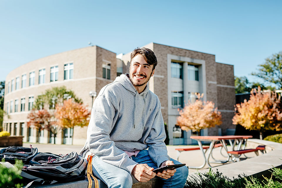 A student sits on a bench in LeChase Commons.