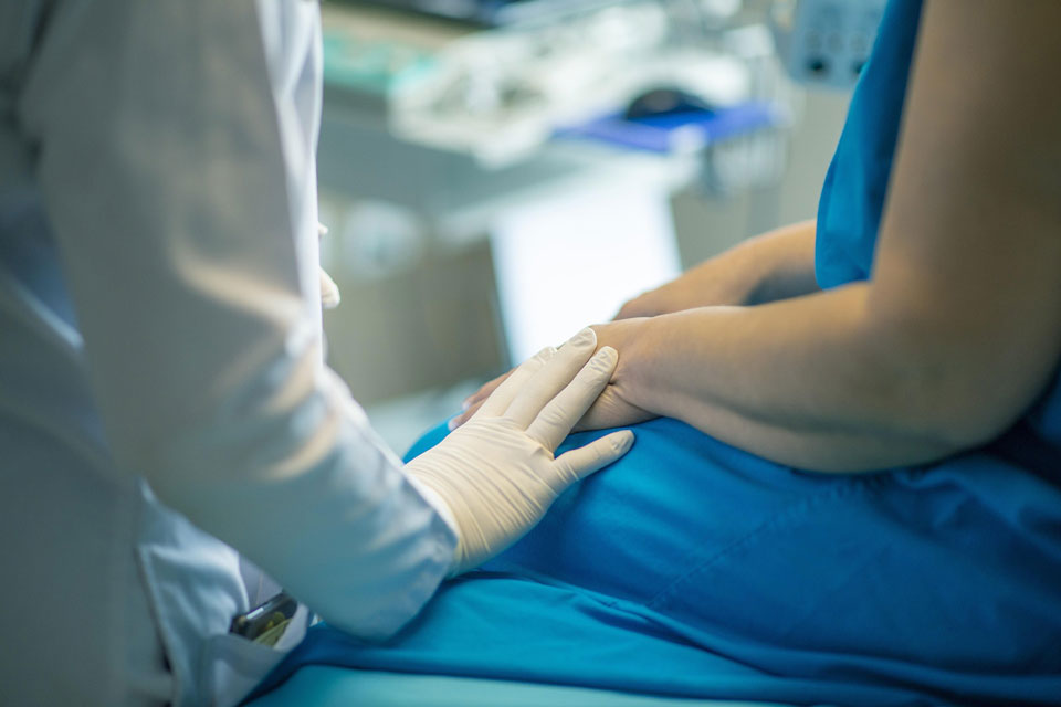 A health care provider offers comfort to a patient.