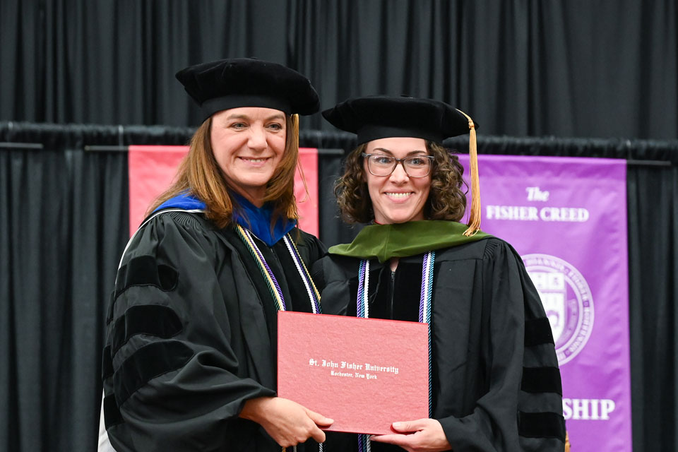 Dr. Christine Birnie poses with a 2025 graduate at Commencement.