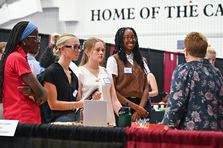 Students visit with an employer at the career and internship fair at Fisher.