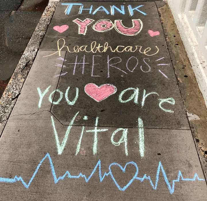 A sidewalk chalk message declaring: Thank you healthcare heroes. You are vital.