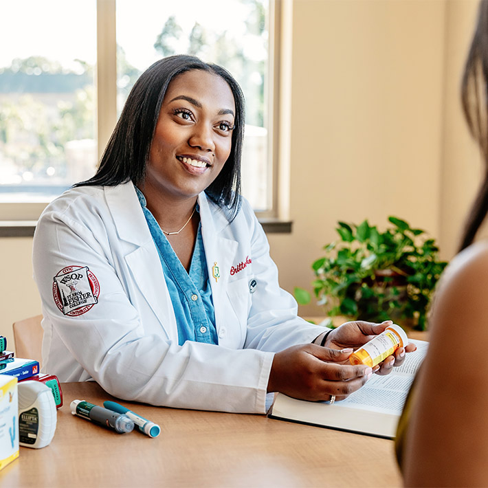 A student pharmacist works with a patient.