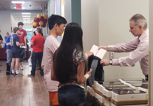 Students receive their iPads during orientation.