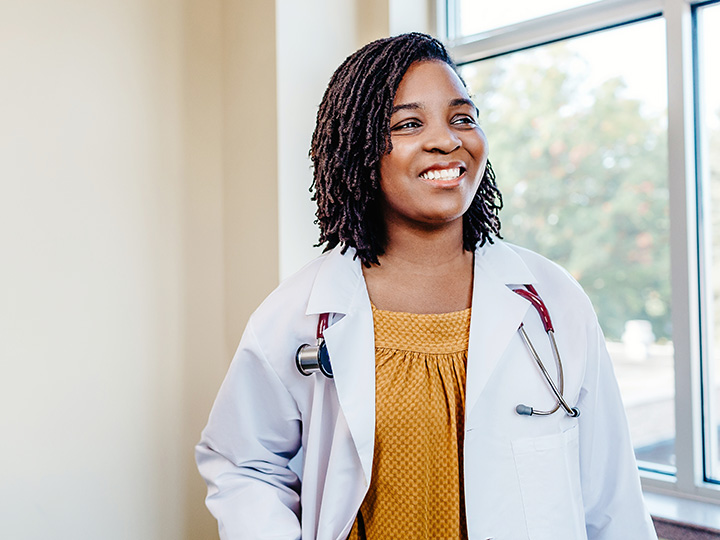 A graduate nursing student smiles.