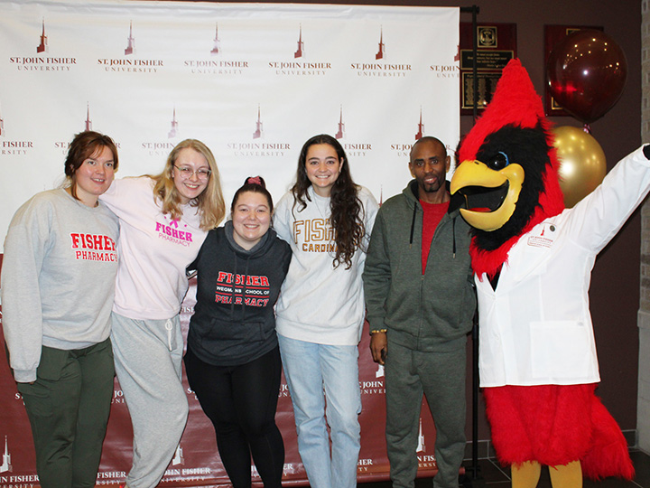 Cardinal mascot dons a White Coat to celebrate National Pharmacy Week with a group of student pharmacists.
