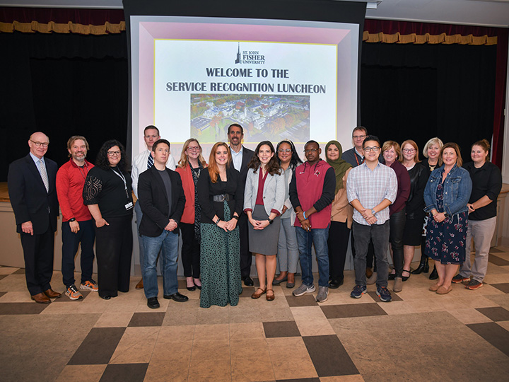 Employees stand together at the service recognition luncheon.