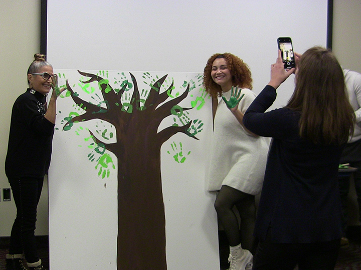 Students paint a tree and add their handprints as leaves during Spirit of Identity Week.
