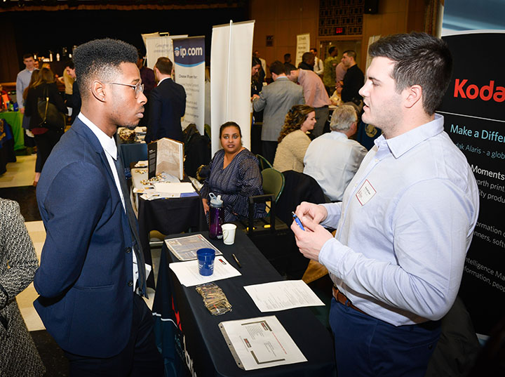 Students take advantage of networking opportunities by speaking with employers at a career resources and readiness job fair. Students may utilize these services during their Fisher years and beyond.