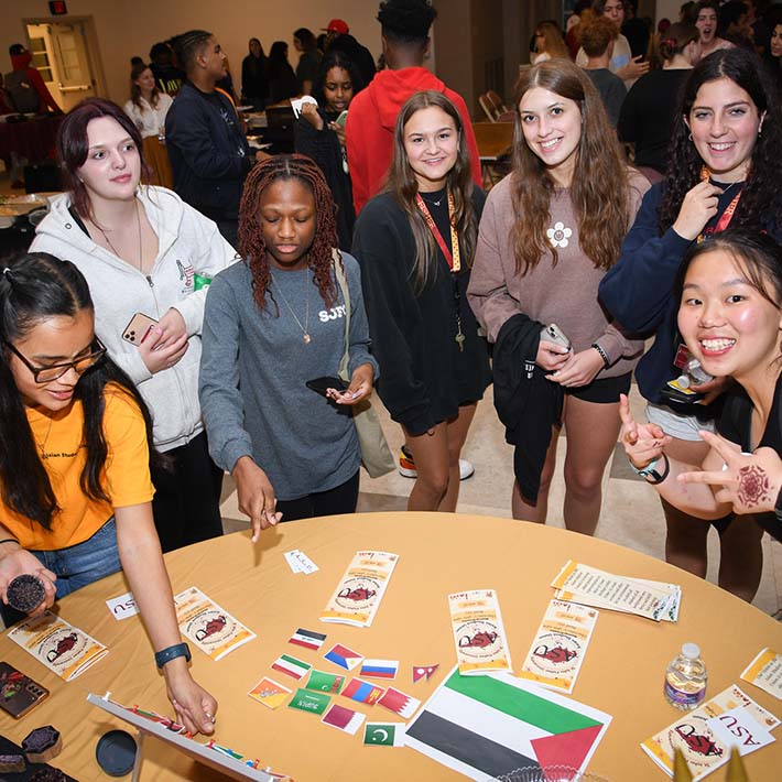 Students participate in a flag identifying activity around a table.