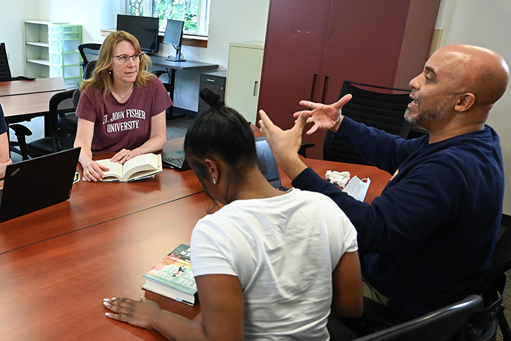 Students conversing around a table in the executive leadership doctoral program.