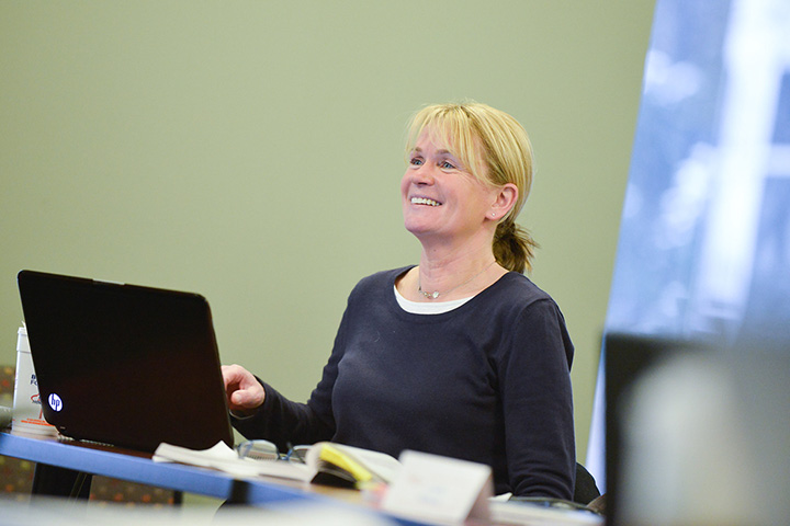 A professor and students review course material.