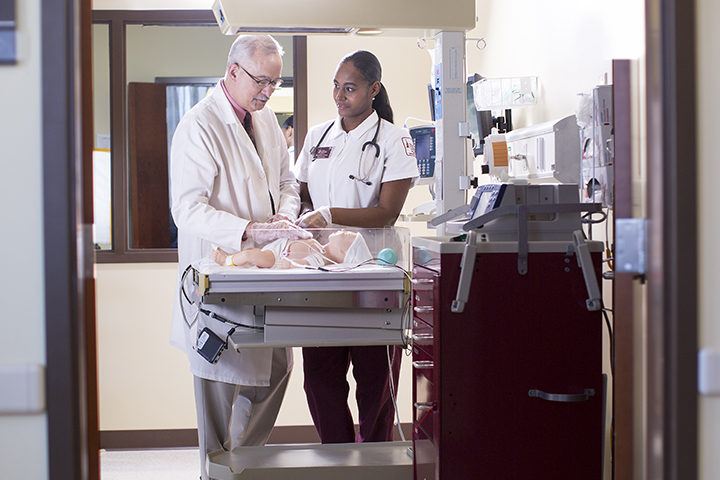 A nursing student practices in the pediatric nursing simulation center.