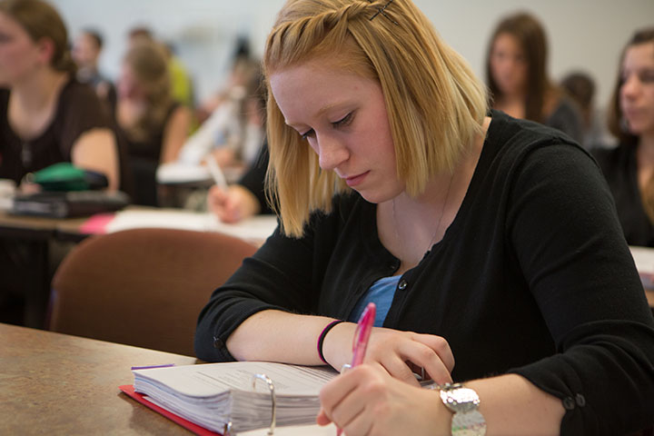 Student engaged in history class taking notes.