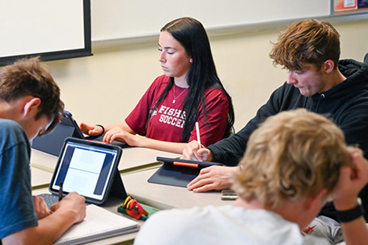 Students in a classroom taking notes on their iPads.