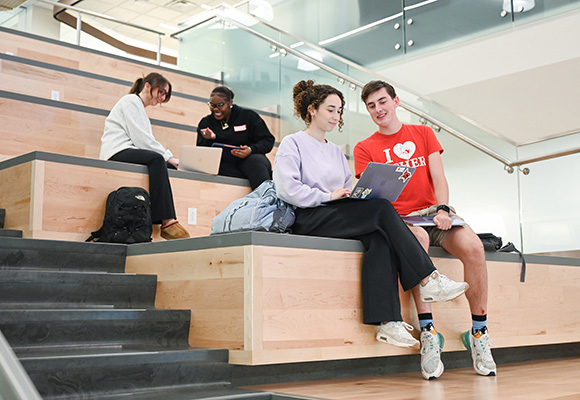 Students sitting together on social stairs at Lavery Library.